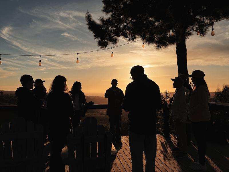 Siluetas de visitantes en la terraza de Glamping Matanzas durante la puesta de sol