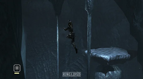 Lara realizando un enorme salto a una estalactita. Lara Croft saltando peligrosamente hacia una estalactita en una cueva oscura y fría en Nepal