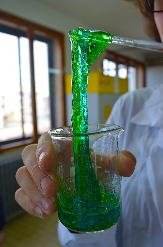 Green slime being lifted out of a beaker