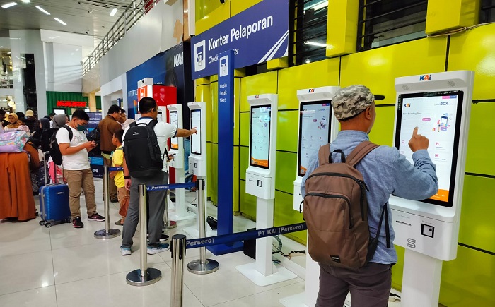 Ilustrasi para pelanggan tengah membeli tiket kereta api di stasiun.