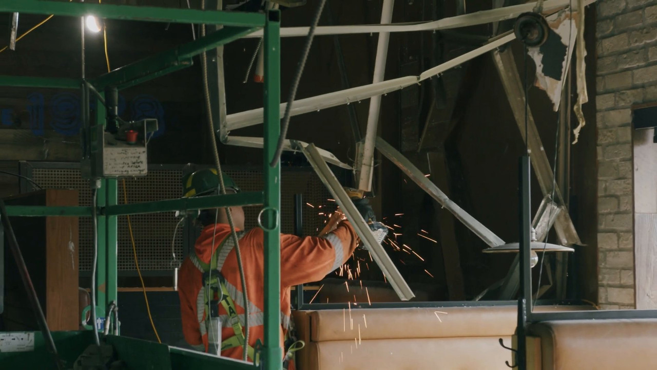 Worker cutting old ceiling framing during the Kelseys demolition