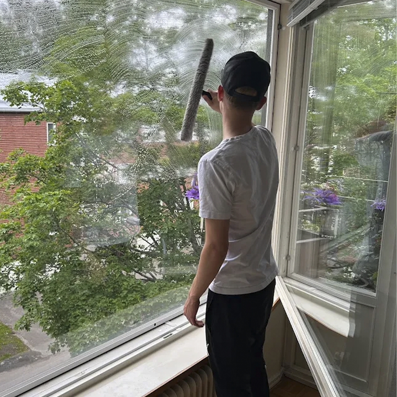 Helsingin Ikkunanpesijöiden Joonatan Lindholm pesemässä ikkunoita