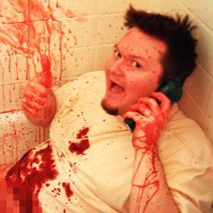 Man covered in fake blood pretending to call