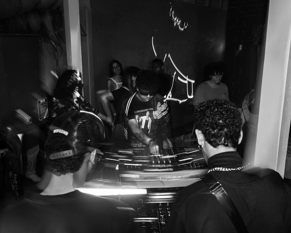DJ BLVCKSUS performing at cyberpunk party with neon lights and futuristic setup