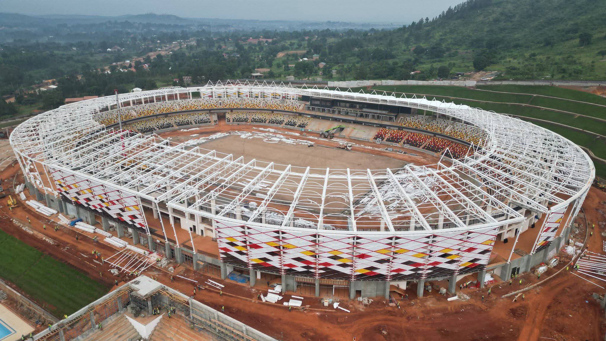 Hoima City Stadium construction site with workers and structural works