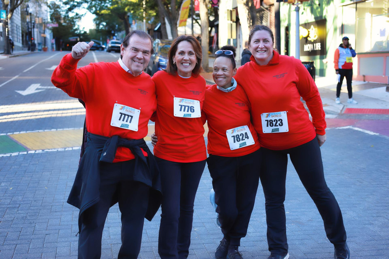 Team in matching red shirts celebrating at the Revolutionary Mile