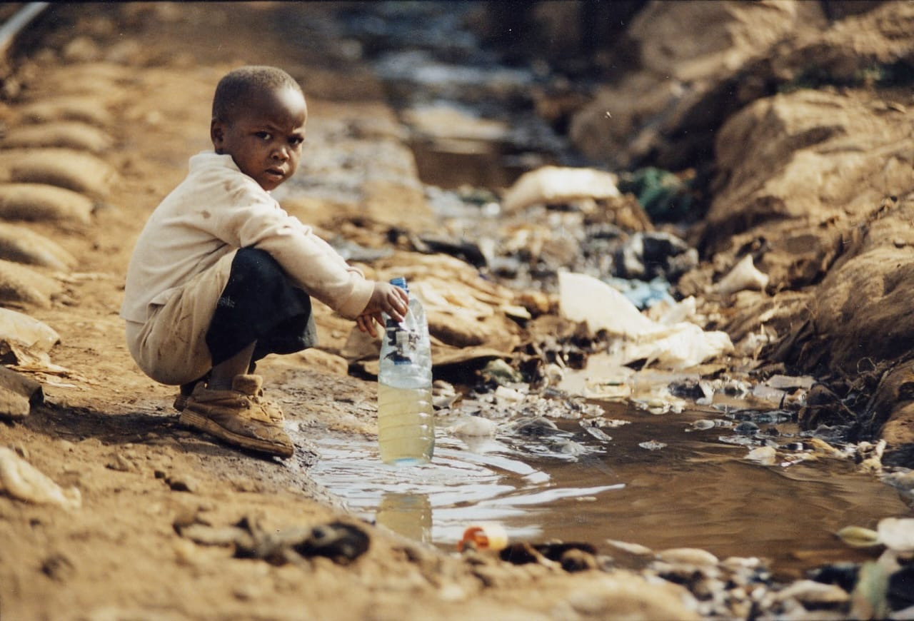 Child collecting water in an underserved environment