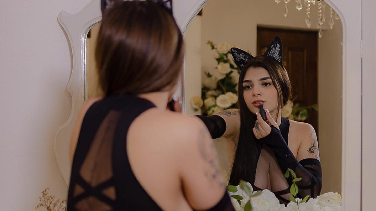 Karely Ruiz de rodillas y vestida de cuero negro estimula a sus fans