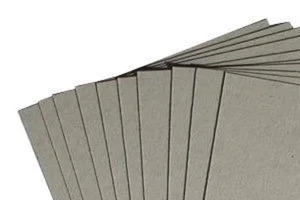 A pile of thick, recycled Sundry Grey Board sheets.