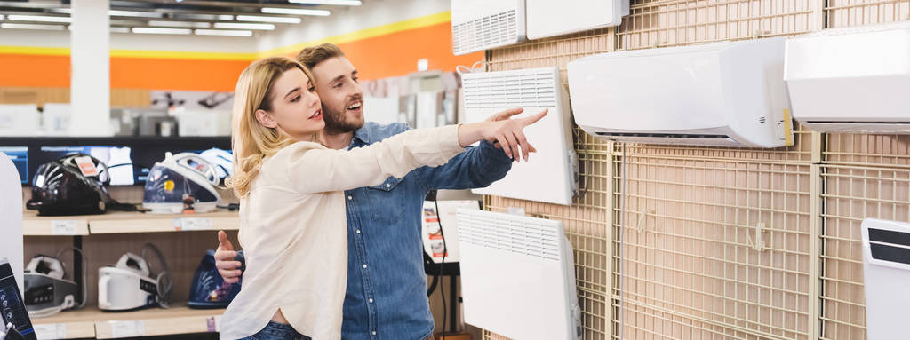 Couple pointing to air conditioning unit