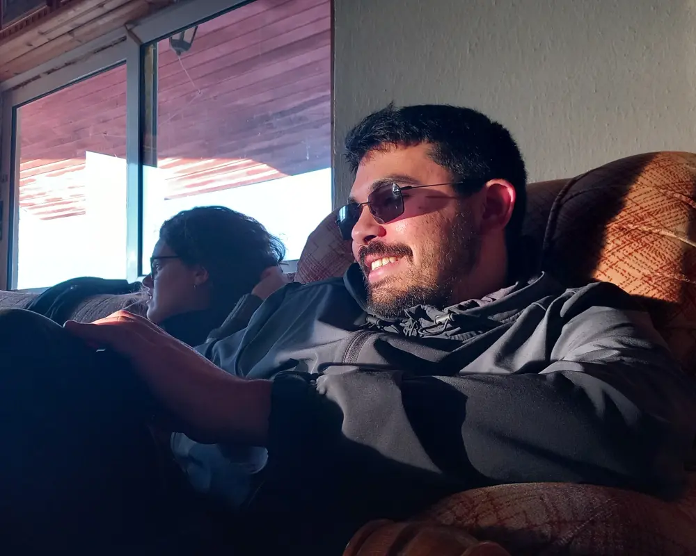 Stavros reading on his phone with a dramatic lighting from the sun