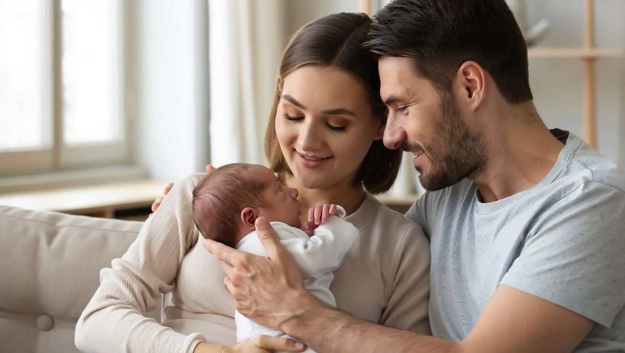 Счастливая семья с новорожденным ребенком дома