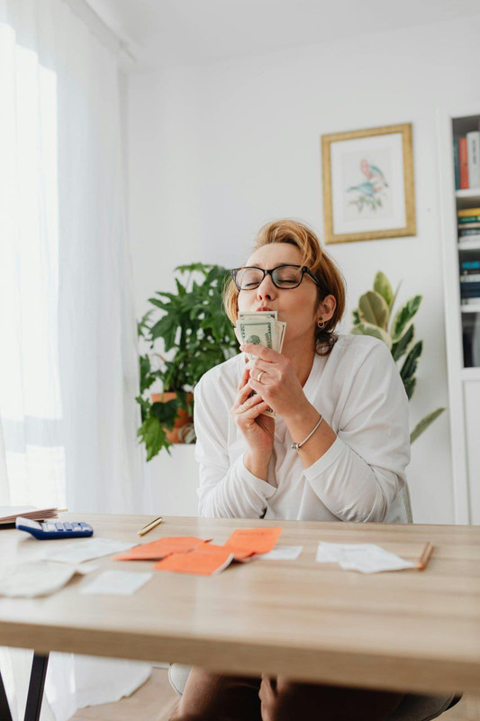 woman happily holding dollar bills showing love for economy