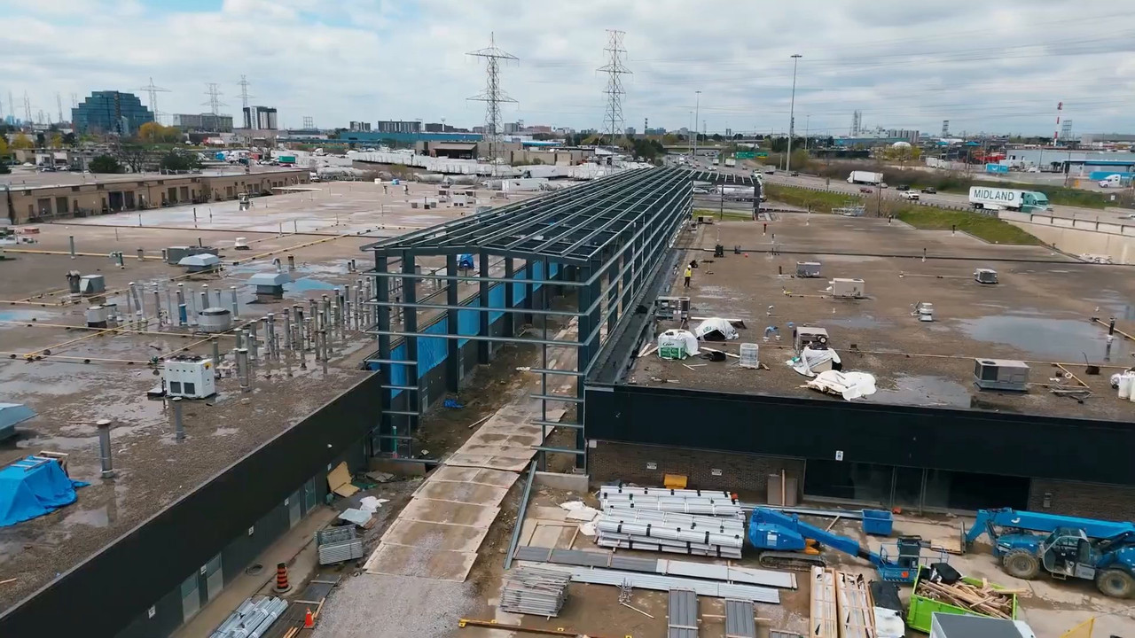 Aerial view of new structural steel rising between the two TWI Foods buildings