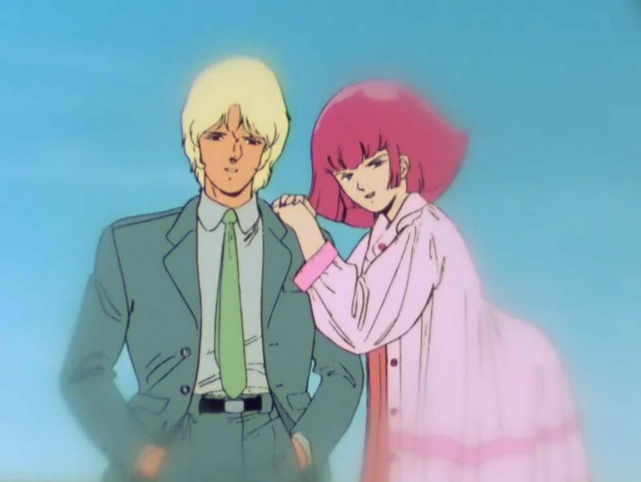 screenshot of Char, without sunglasses, wearing a casual suit and smiling at the viewer; Haman wears an oversized cotton blouse/dress and is leaning into him with her hands folded on his shoulder. the vibe is idyllic and Haman looks very innocent