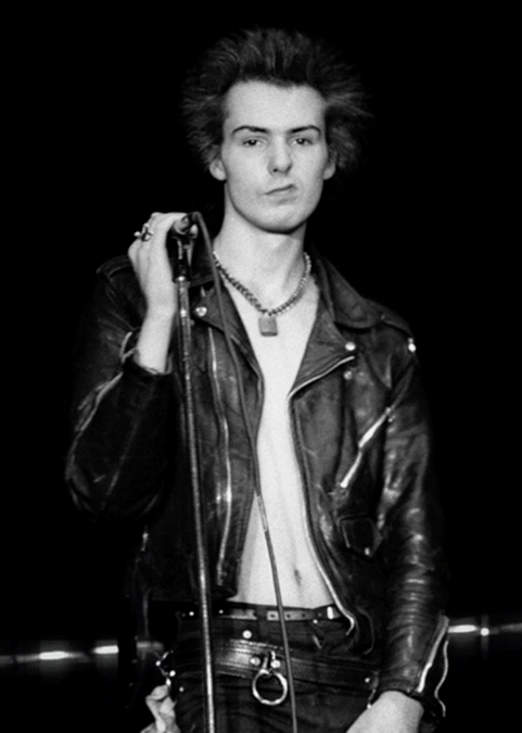 Sid Vicious with his striking hairstyle holds the microphone