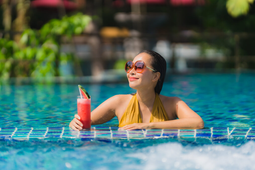 portrait beautiful young asian woman leisure relax smile with watermelon juice around swimming pool
