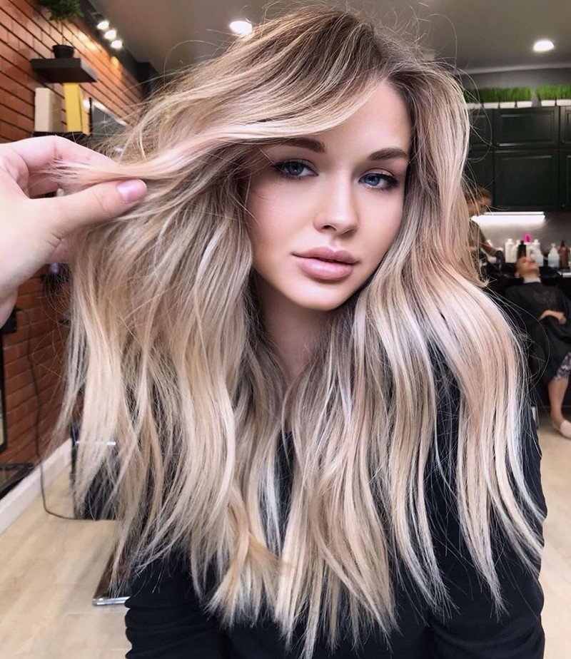 Blue-eyed girl with long wavy beige blonde hair