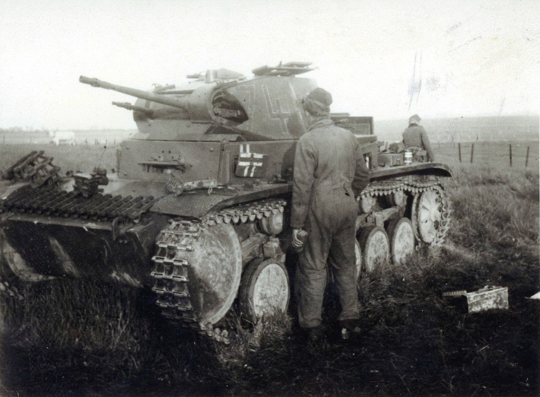 Немецкий танкист осматривает повреждение легкого танка Pz.Kpfw. II.