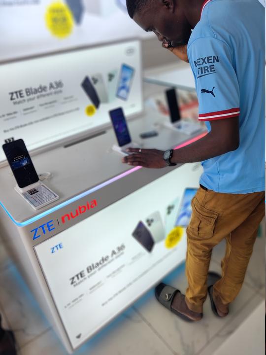 Customer comparing two smartphones while deciding on a loan purchase