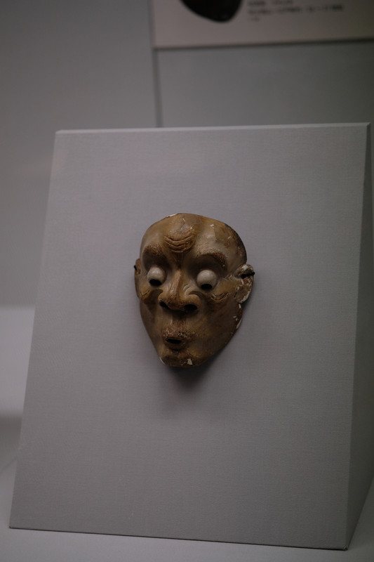 A Noh or Kyogen mask with an unsettling expression