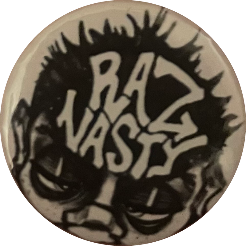 a black & white pin with a punk-looking person with short hair-- their hair taking up most of the pin. in their hair are the words 'RAZ NASTY' in white-- the name of a cool artit