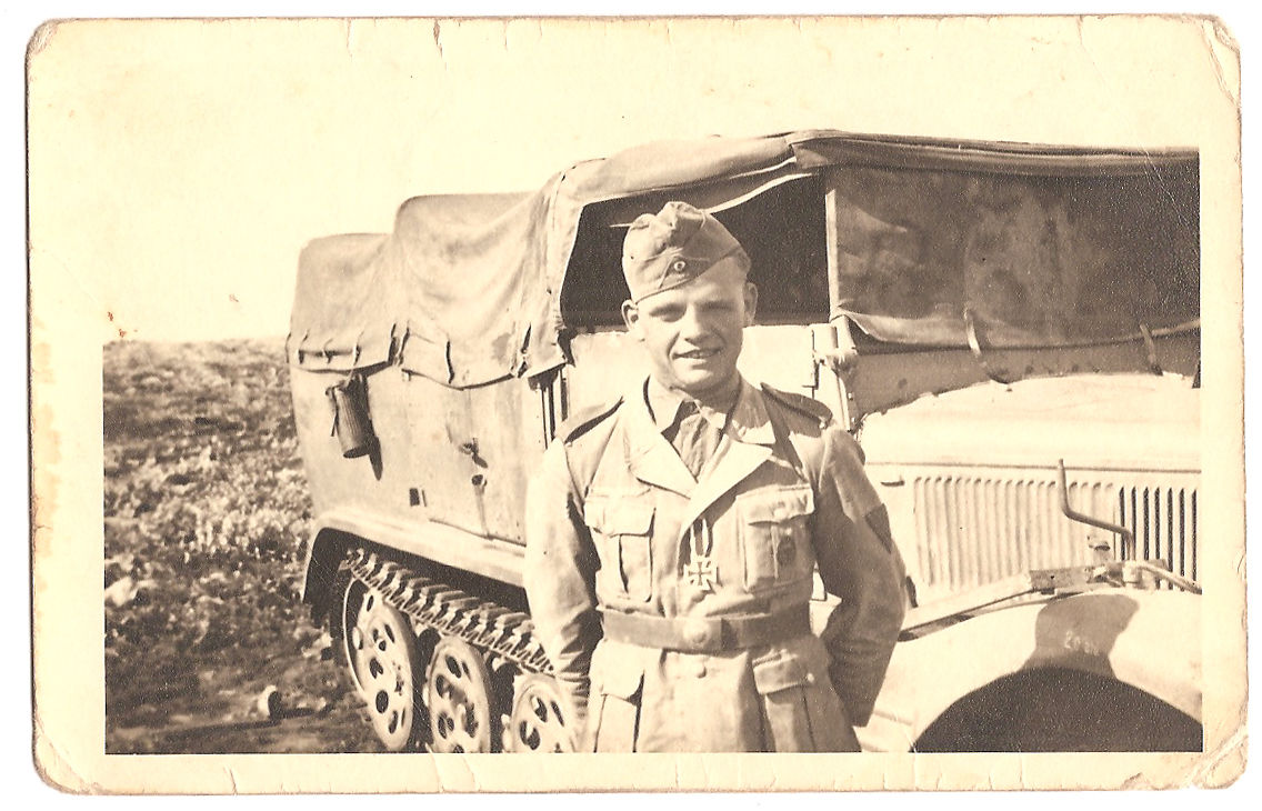 Afrika Kämpfer,mit Orden,vor Kettenfahrzeug