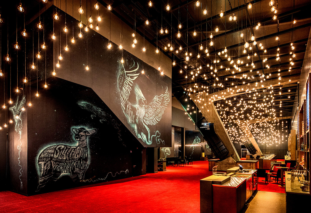 Foyer des Harry Potter Theaters in Hamburg mit tausenden warmen Pendelleuchten von Studio De Schutter