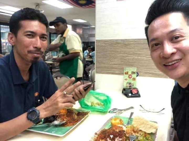 dua lelaki sedang makan di restoran