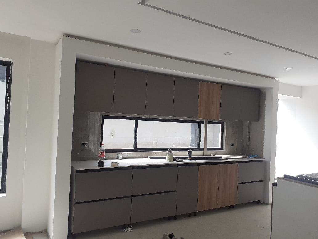 Frente de cocina moderna gris y madera en obra