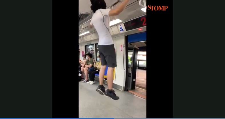 Tangkapan layar video pria melakukan gerakan pull-up di dalam gerbong MRT Singapura.