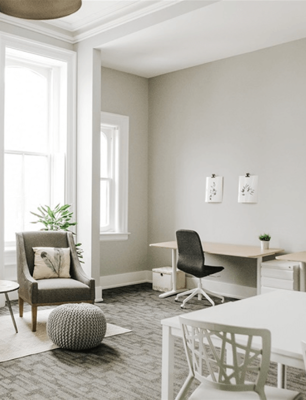 Modern, brightly lit office lounge area with minimalist furniture.