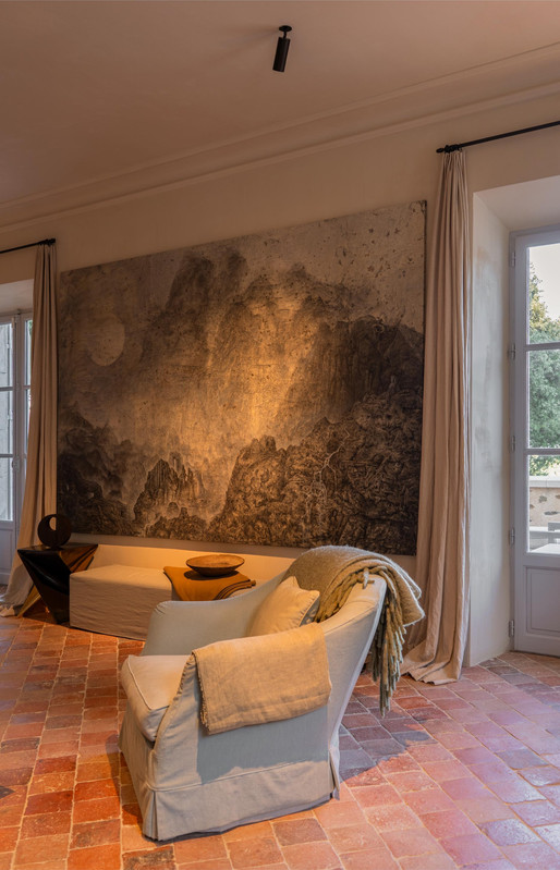 Luxuriöse Loungebeleuchtung in Château Bénat mit fokussierter Kunstwerkbeleuchtung, warmen Bodenreflexionen und zurückhaltenden architektonischen Strahlern