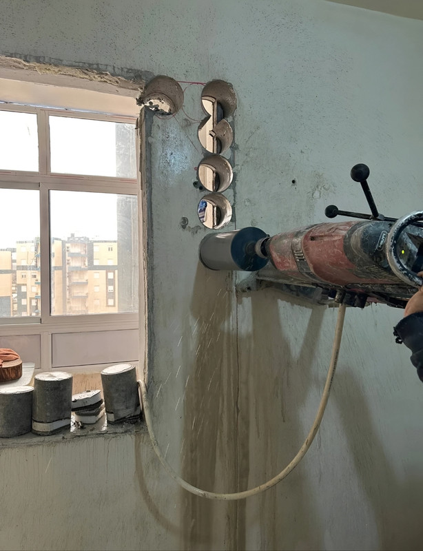فتحة مستطيلة كبيرة مقطوعة بدقة في أرضية خرسانية سميكة.