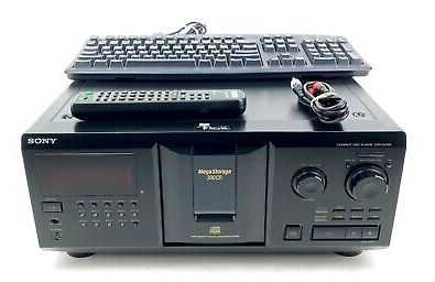 photo of sony cdp-cx335 with remote and ps2 keyboard on top