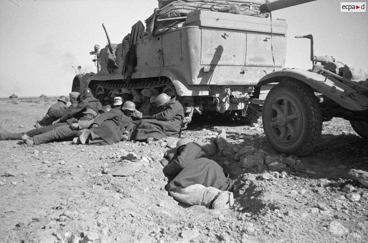 Des artilleurs allemands endormis devant un semi-chenillé Sd.kfz.7, on aperçoit une partie de la rem