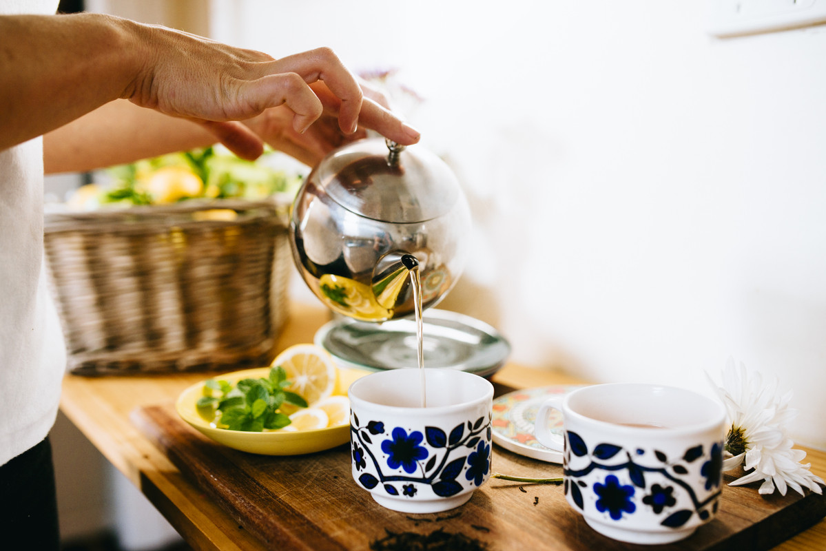 homme qui verse du thé dans une tasse