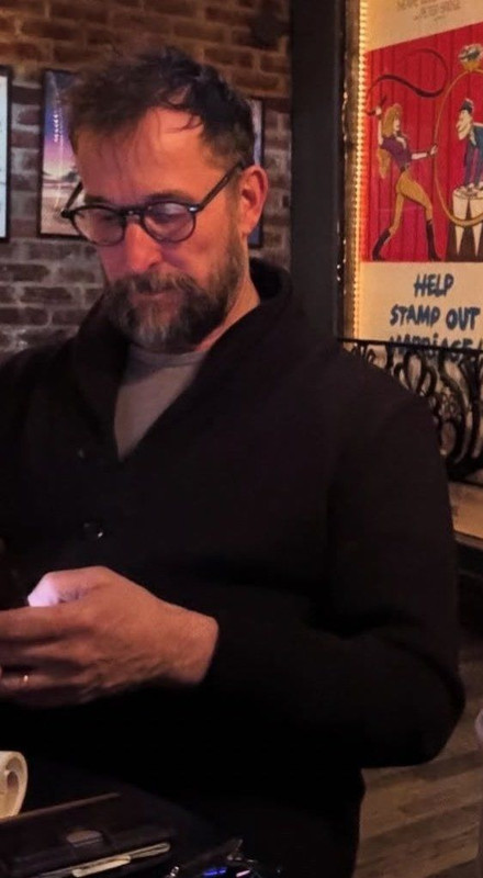 Sneaky picture of Robby, glasses on, looking down at his phone