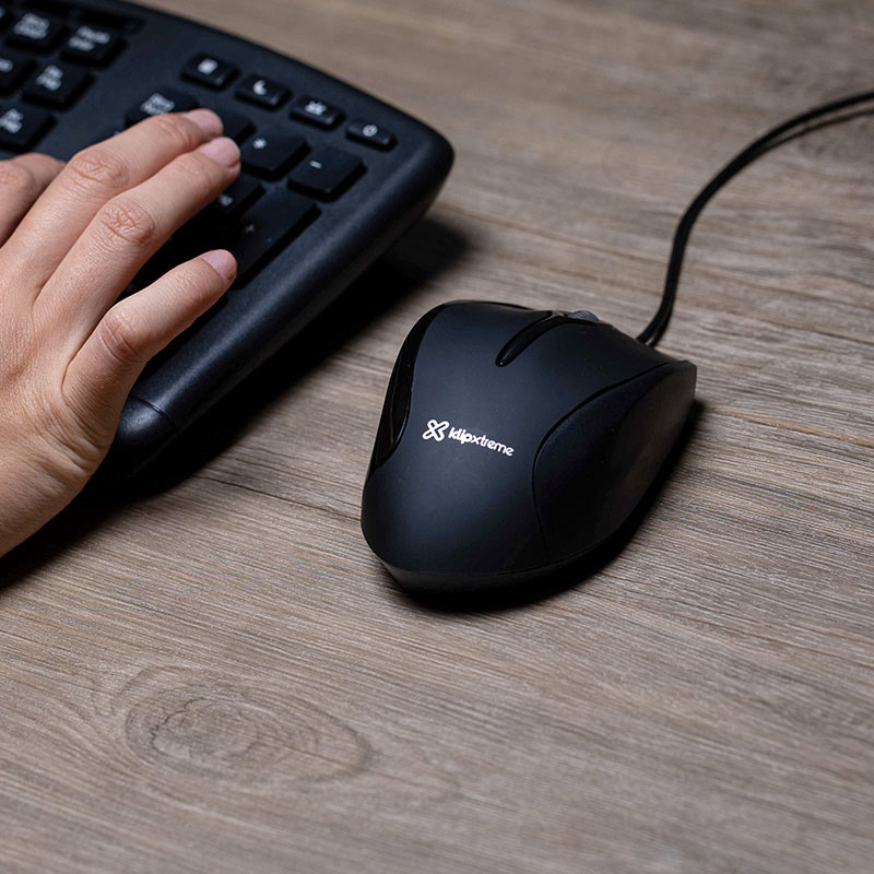 Una persona sosteniendo el mouse ergonómico KlipXtreme, mostrando su ajuste cómodo.