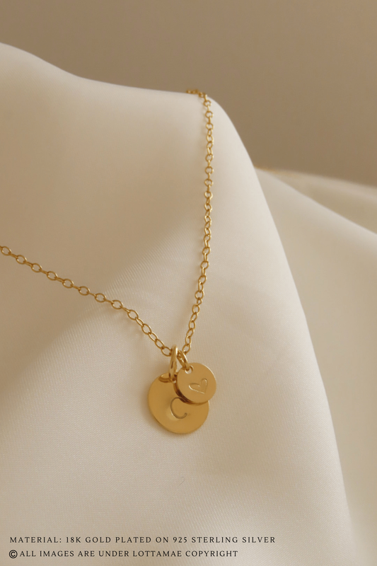 This dainty and personalizable disk necklace is the perfect way to show off your personality. Crafted from 925 sterling silver and 18k gold plated, this necklace is sure to turn heads wherever you go. The initial of your choice will be hand stamped onto the disk, making it a totally unique piece of jewelry that you can wear with pride. Whether you choose your own initial or a special memento of someone close to you, this necklace is a wonderful way to express who you are. Perfect for everyday wear, it will add a touch of elegance to any outfit. Add this beautiful and personalized piece of jewelry to your collection today!