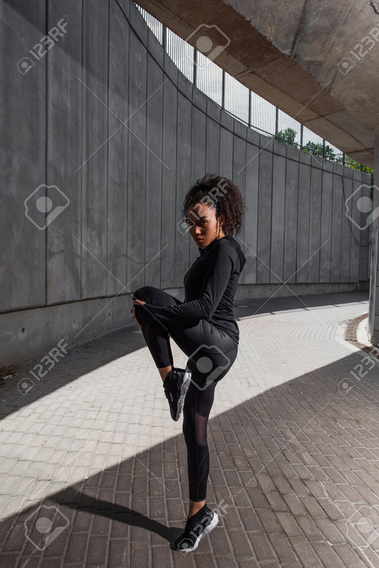 blacks649 es 123rf com african american sportswoman warming up on urban street