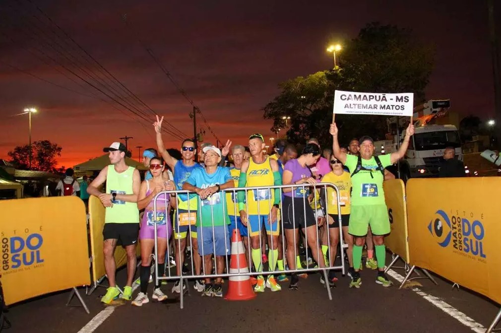 Na primeira fileira da largada, o cabelereiro Autemar Aparecido da Silva Matos, de 58 anos, levantando bandeira com o nome de sua cidade, Cmapuã (Foto: Juliano Alemeida)