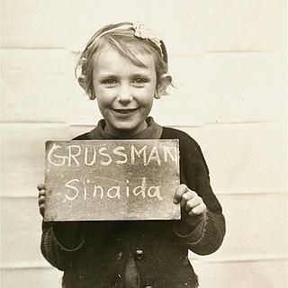 La niña Sinaida Grussman, acogida por un campamento en la región de Bavaria, muestra un cartel con su nombre con la esperanza de ser localizada por su familia. La imagen fue publicada en periódicos