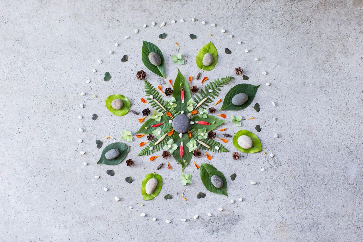 Nature mandala made from leaves, flower petals, and pebbles—part of a simple summer art activity to support stress relief and mindfulness.