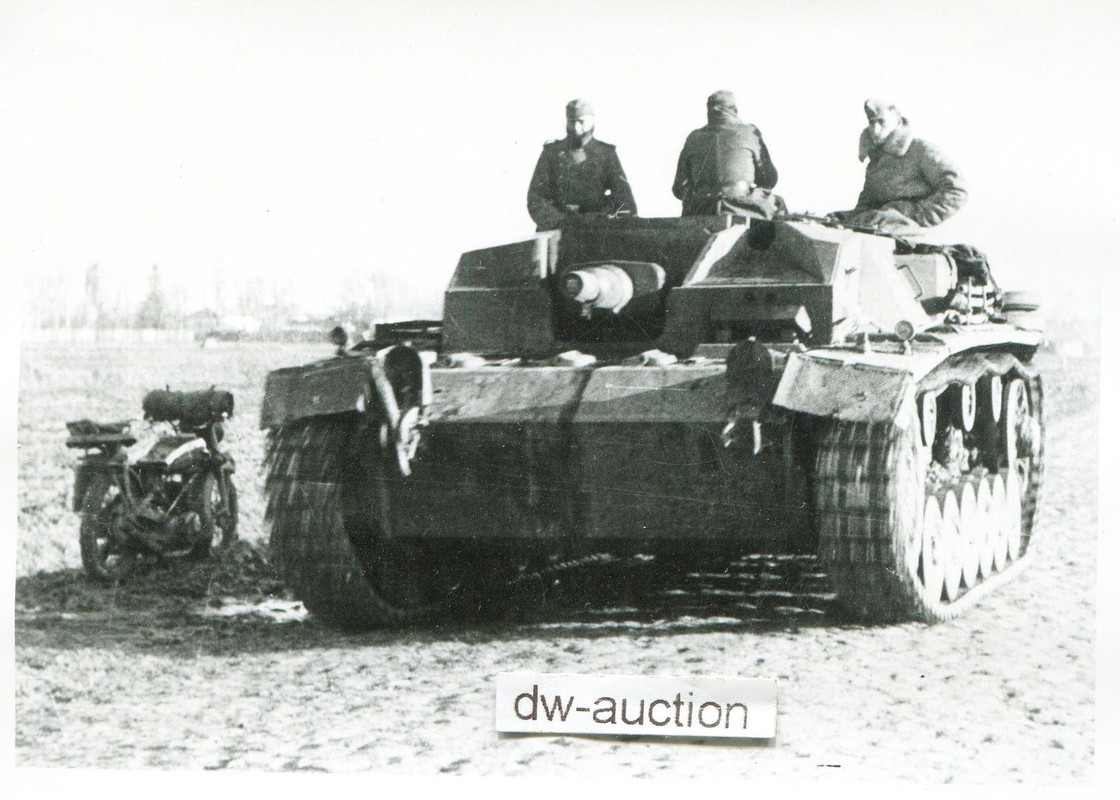 Sturmgeschütz mit Besatzung neben Motorrad