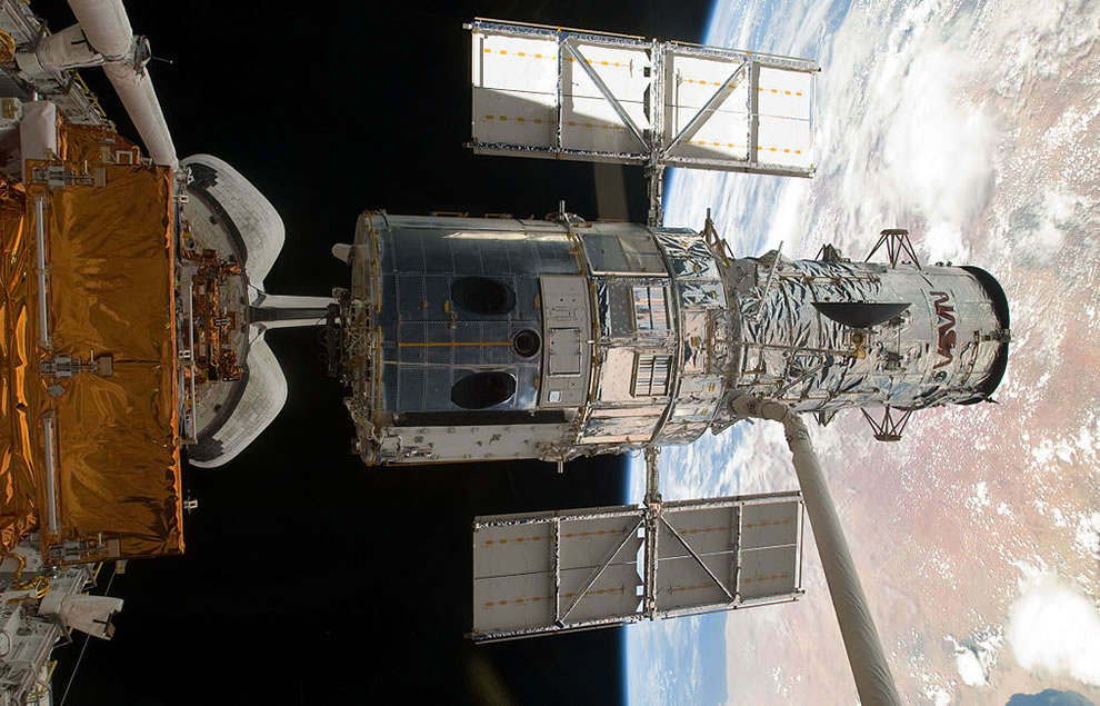 The-Hubble-Space-Telescope-lifted-out-of-the-payload-bay-of-Atlantis-moments-before-it-is-released-i