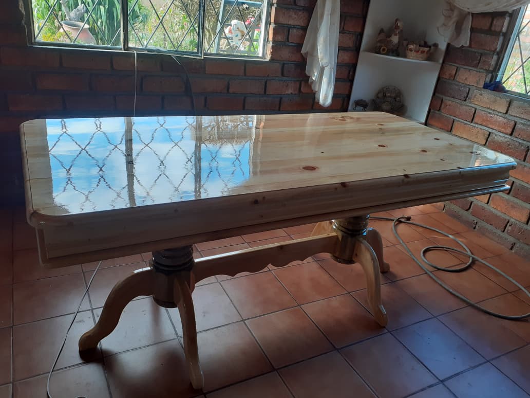 Mesa de comedor de madera clara en comedor con ladrillo