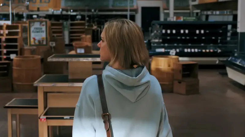 still frame from pluribus showing Carol entering an empty sprouts grocery store