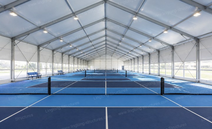 Pickleball players enjoying a game inside the modular tent facility with clear-span design