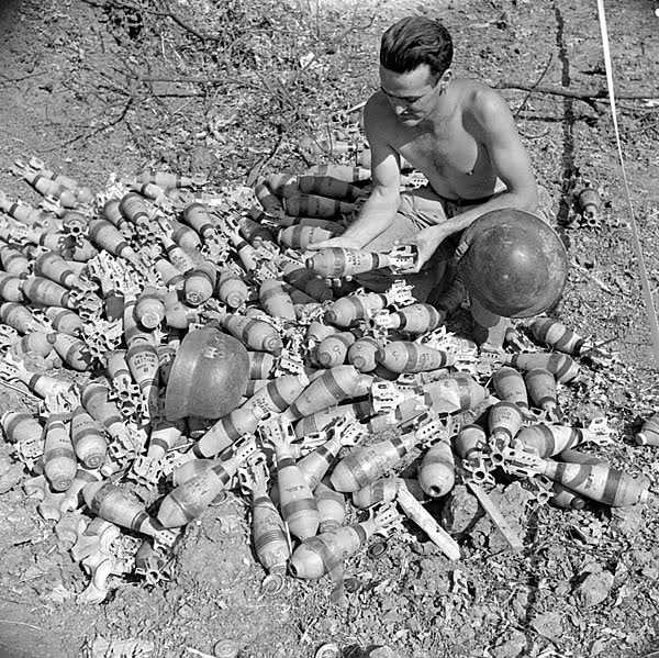 Soldado examinando un grupo de granadas de mortero abandonadas por unidades  Panzer Grenadier alemanas cerca de Aquino. 22 de mayo de 1944, Aquino, Italia